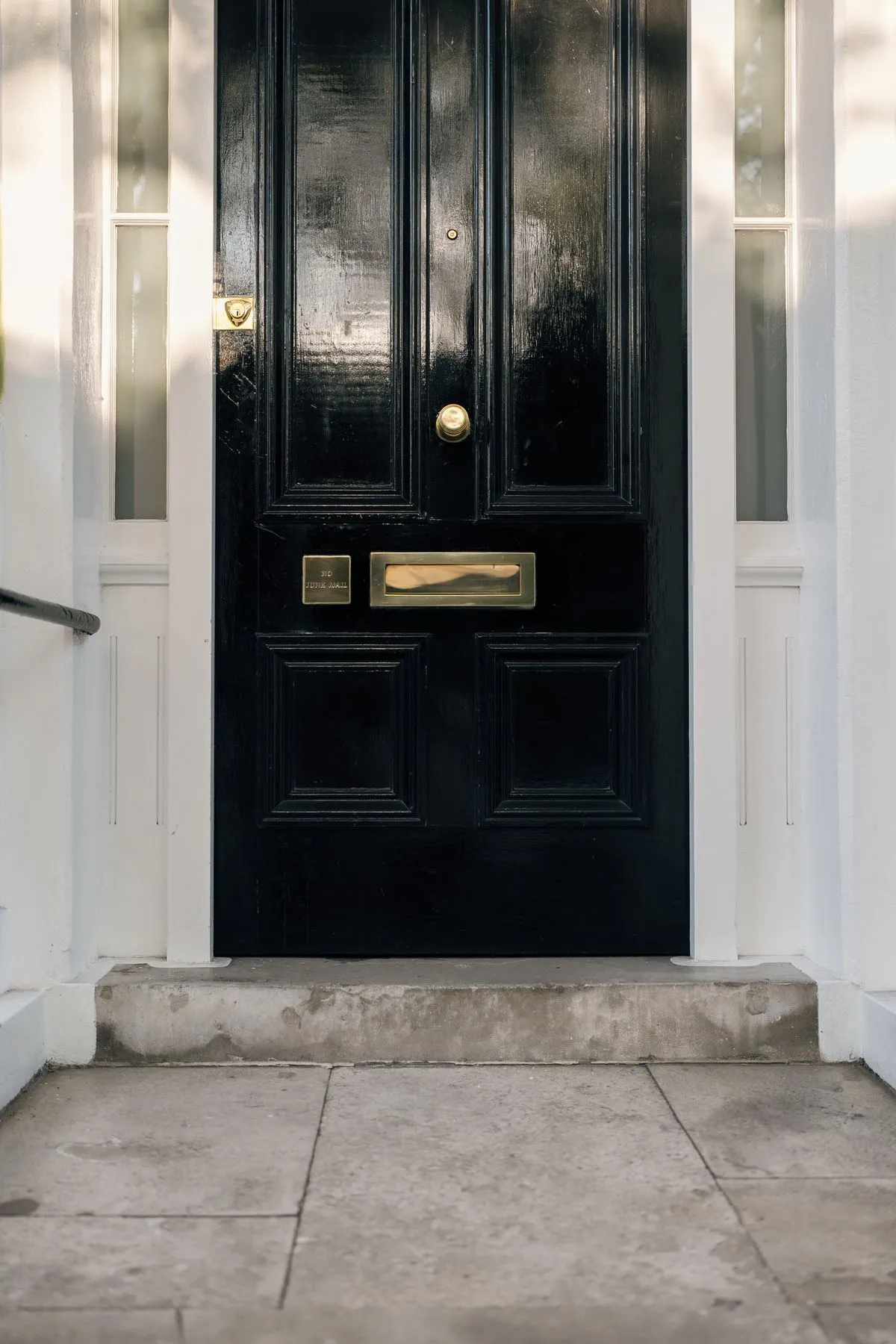 An elegant black front door with brass hardware and detailing