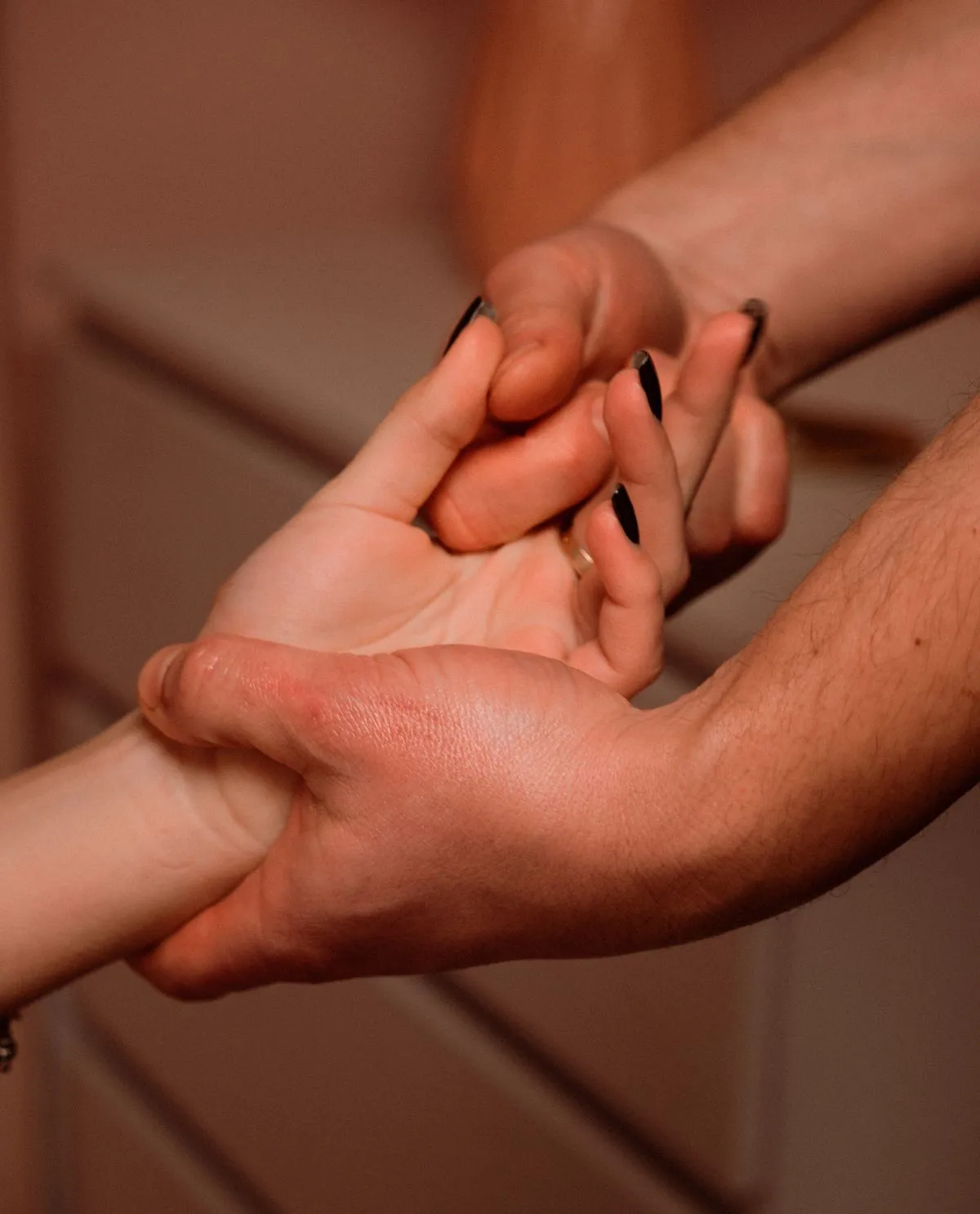Two hands gently holding one another in a close embrace