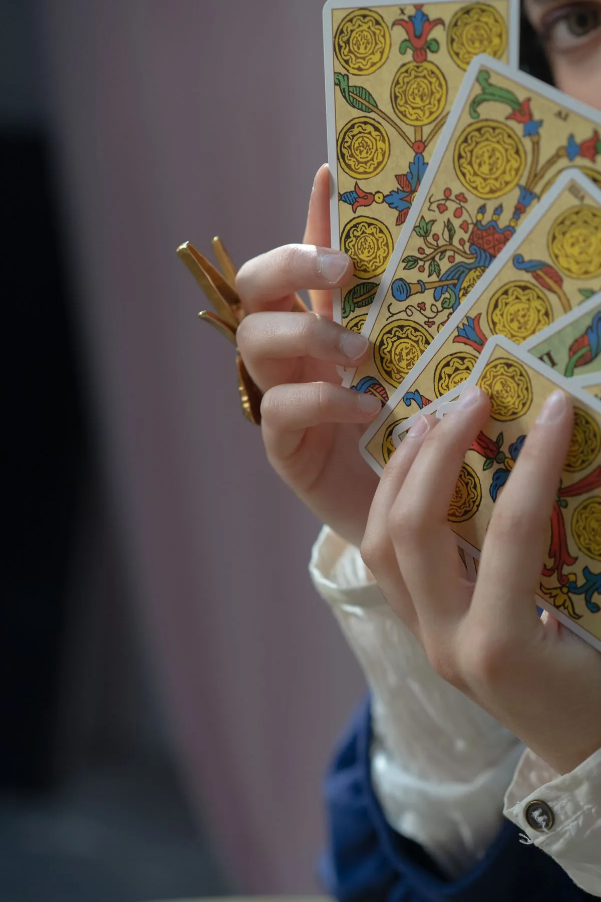Hands holding a fan of tarot cards during a reading