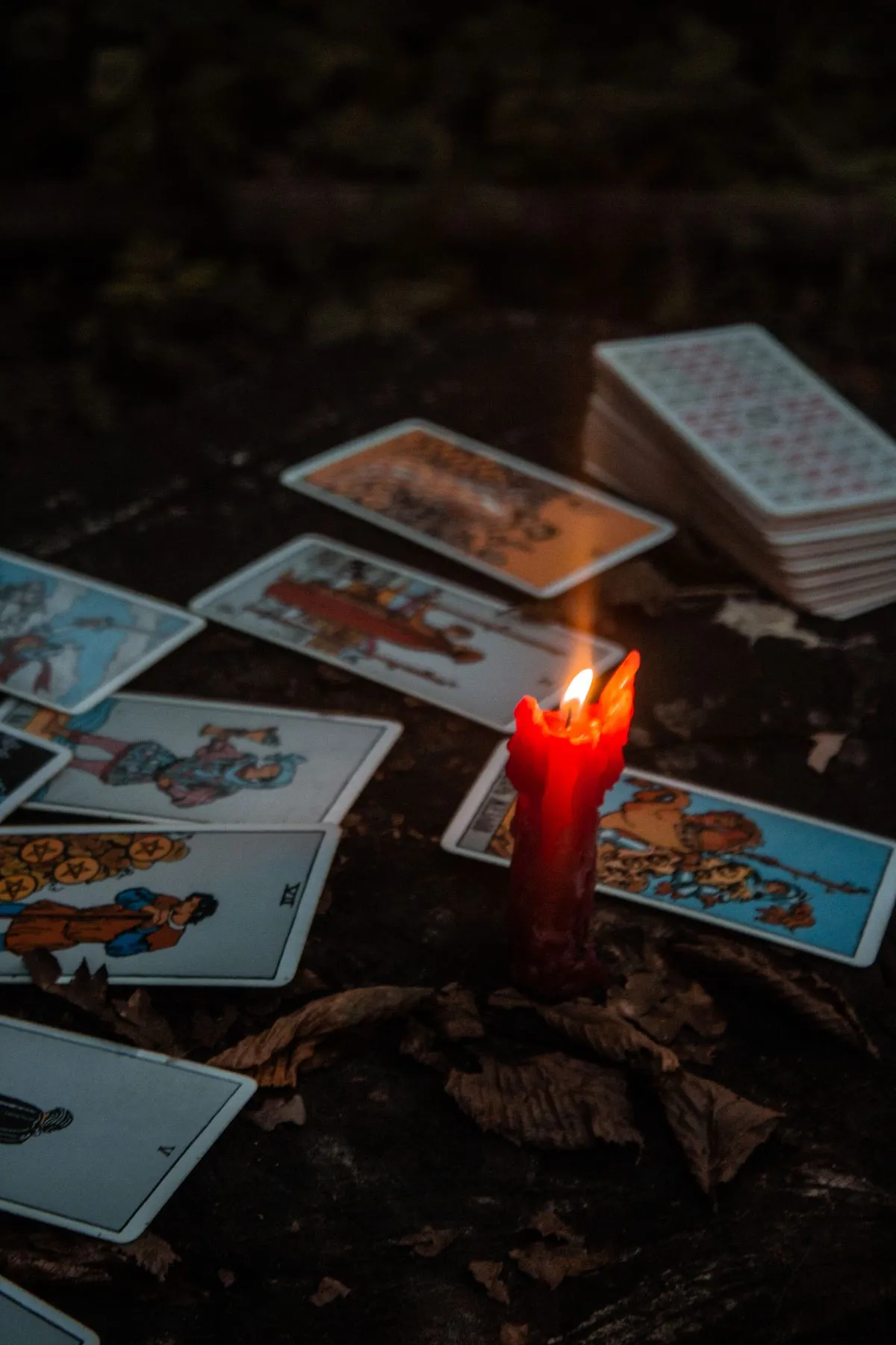 Tarot cards laid out beside a lit candle, creating a mystical atmosphere