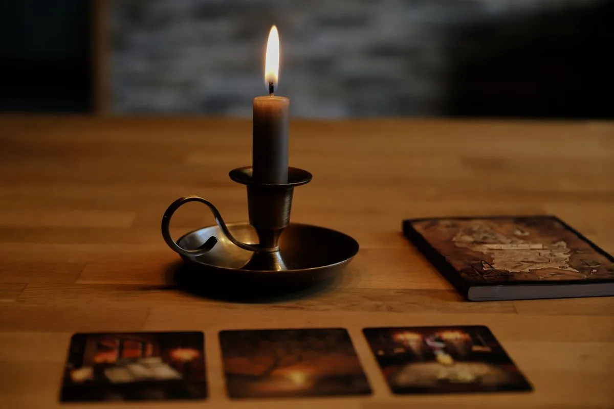 A vintage candleholder beside tarot cards and an aged book